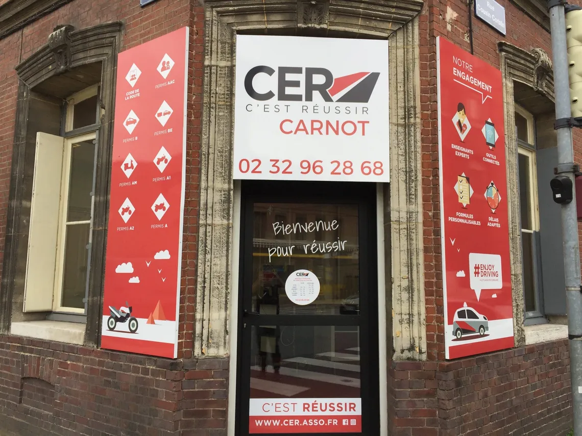 Devanture en brique de l'agence CER Elbeuf, enseigne « CER Carnot », à l'angle du cours Carnot